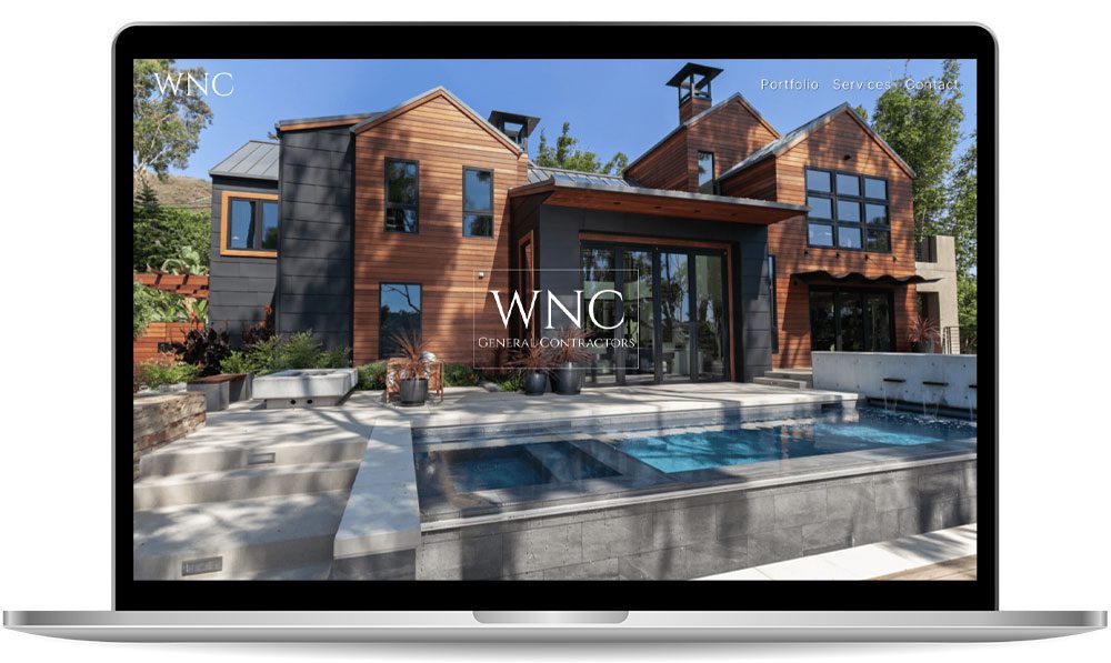 wnc A laptop screen displaying a website for WNC General Contractors, featuring a modern house exterior with large windows, a swimming pool, and surrounding greenery.